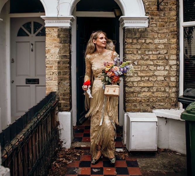 Bride on the Way to the ceremony in Gold Dress and Wedding Bouquet