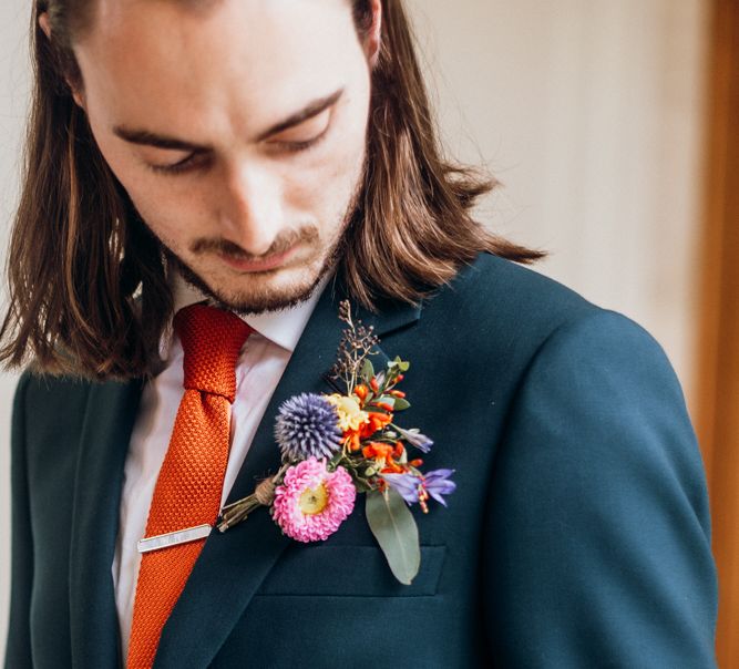 Floral Buttonhole with Orange Tie and Navy Suit