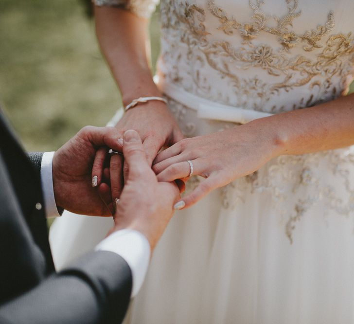 Groom putting ring on the bride