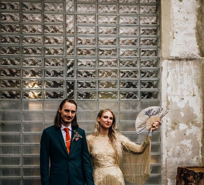 Groom in Navy Suit with Orange Tie and Bride in Gold Wedding Dress