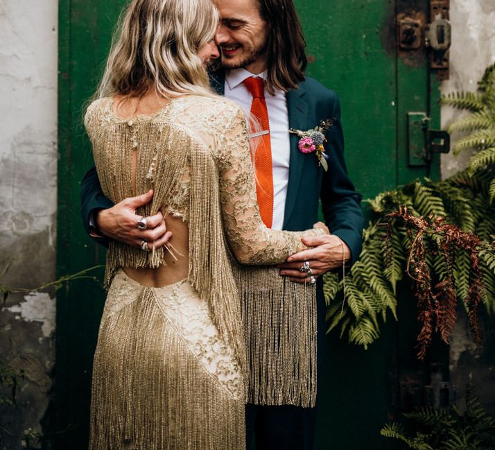 Bride in Gold Fringe Dress with Groom in Navy Suit with Orange Tie and Floral Buttonhole