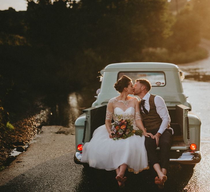 Bride and groom in back of a pickup truck