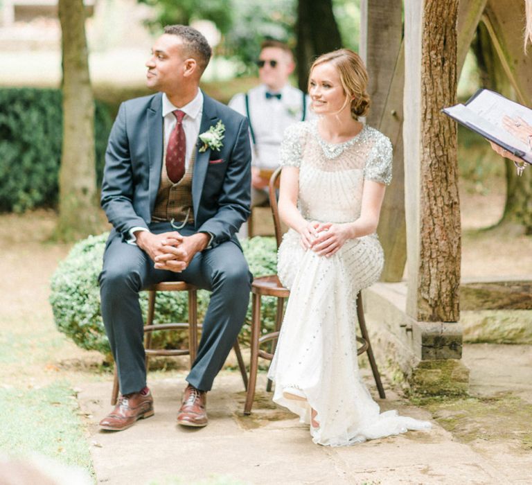 Bride in Beaded Wedding Dress and Groom in Dark Suit &amp; Check Waistcoat at Outdoor Wedding Ceremony