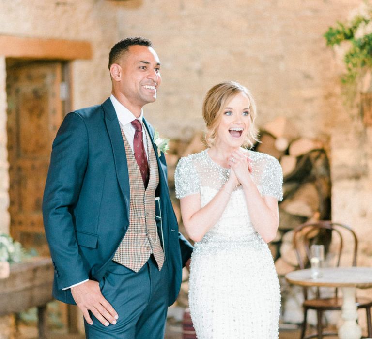 Ecstatic Bride in Beaded Wedding Dress and Groom in Dark Suit &amp; Check Waistcoat