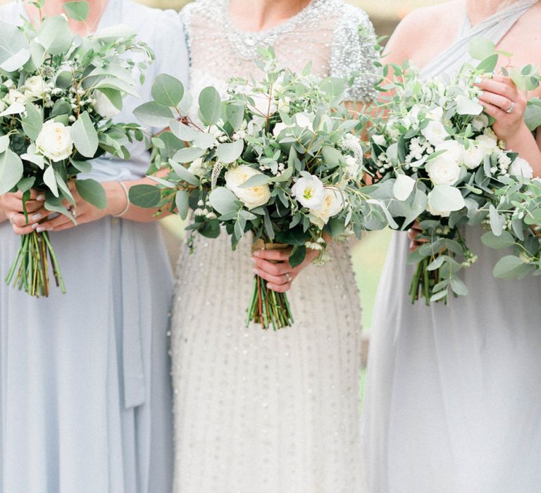 Bride and Bridesmaids Holding White and Foliage Wedding Bouquets