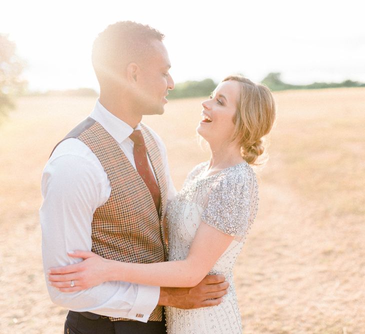 Sunset Portrait with Bride in Beaded Wedding Dress and Groom in Dark Suit &amp; Check Waistcoat