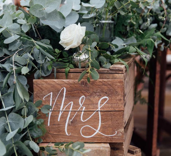 Top Table Heavy Eucalyptus Foliage with White Roses | DIY Pallet Signage | White Calligraphy | French Rustic at Northbrook Park in Surrey | Images by Charlotte Bryer-Ash