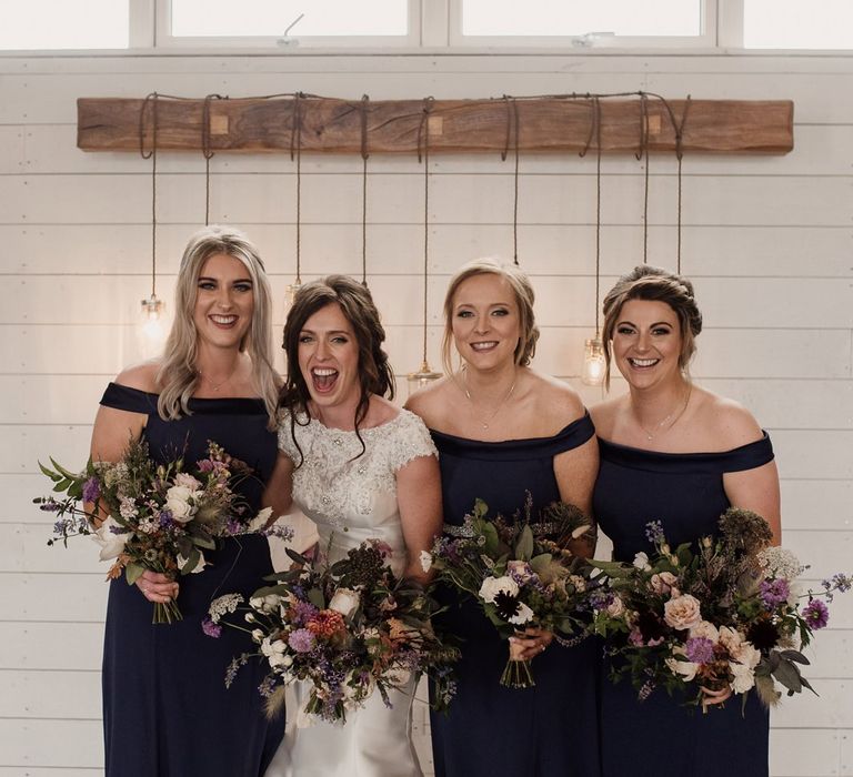 Bridal party portrait with bridesmaids in navy Bardot dresses