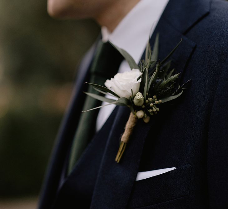 Groom in Navy Three-Piece Suit from Suit Supply with Green Tie | Buttonhole of Eucalyptus, Thistle and White Rose | Emerald Green Bridesmaid Dress for a Winter Wedding at Middleton Lodge | Georgina Harrison Photography