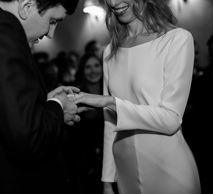 Bride in Long Sleeved Andrea Hawkes Dress with Bateau Neck and Low V-Back with Buttons | Groom in Navy Three-Piece Suit from Suit Supply with Green Tie | Gold Wedding Ring by Laura Lee Jewellery | Emerald Green Bridesmaid Dress for a Winter Wedding at Middleton Lodge | Georgina Harrison Photography