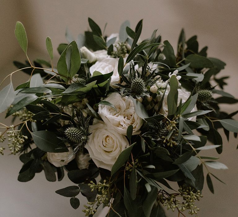 Bridal Bouquet with Eucalyptus, White Roses, White and Blue Thistles and Ferns | Emerald Green Bridesmaid Dress for a Winter Wedding at Middleton Lodge | Georgina Harrison Photography