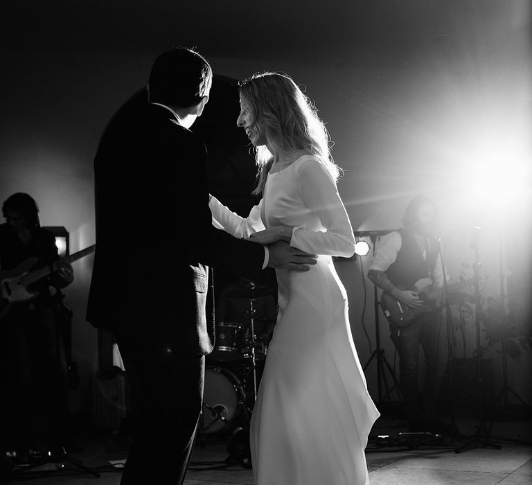 Bride in Long Sleeved Andrea Hawkes Dress with Bateau Neck and Low V-Back with Buttons | Groom in Navy Three-Piece Suit from Suit Supply with Green Tie | First Dance | Emerald Green Bridesmaid Dress for a Winter Wedding at Middleton Lodge | Georgina Harrison Photography