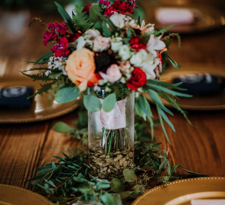 Wedding Reception Décor | Pinwheel Table Configuration | Gold Charger Plates | Eucalyptus Garland | Colourful Bouquet of Pink, Orange and Red Flowers with Ferns, Eucalyptus and Greenery | Tea Lights | Rifle Paper Co. Trainers for Informal Wedding in Fort Worth, Texas | Paul &amp; Nanda Photography