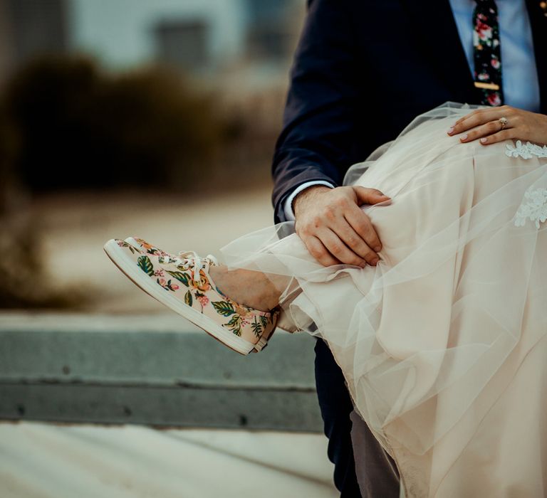 Blush Rifle Paper Co. Trainers with Pink Flowers and White Laces | Bride in Sleeveless High-Neck Stella York Gown with Lace Overlay and Gold Underskirt | Groom in Navy Suit and Floral Tie | Pink Buttonhole | Rifle Paper Co. Trainers for Informal Wedding in Fort Worth, Texas | Paul &amp; Nanda Photography