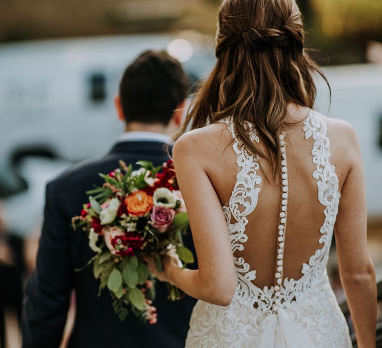 Bride in Sleeveless High-Neck Stella York Gown with Lace Overlay and Gold Underskirt | Half Up Half Down Wedding Hair | Groom in Navy Suit and Floral Tie | Pink Buttonhole | Colourful Bridal Bouquet of Pink, Orange and White Flowers with Ferns, Eucalyptus and Greenery | Rifle Paper Co. Trainers for Informal Wedding in Fort Worth, Texas | Paul &amp; Nanda Photography