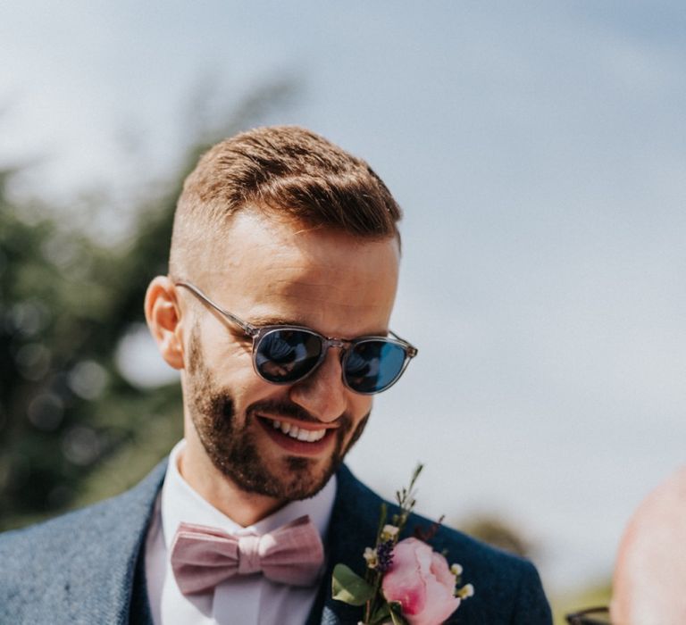 Groom with blush bow tie and floral buttonhole at DIY wedding decor celebration