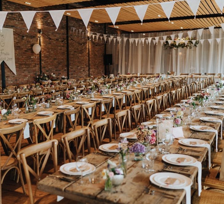 Beautiful rustic wedding setting with pastel flowers with DIY wedding decor and wedding bunting