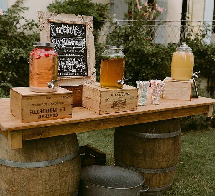 Cocktail Station with Drinks Dispensers | Festoon Lit Outdoor Boho Wedding at Chateau le Tour, France | Adam and Grace Photography | Head and Heart Films