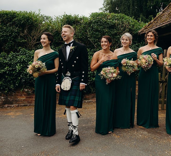 Bridesmaids in green dresses wait for bride in layered wedding dress