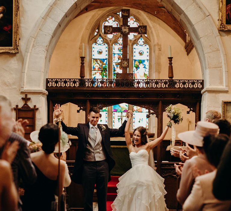 Bride in layered wedding dress celebrates with husband