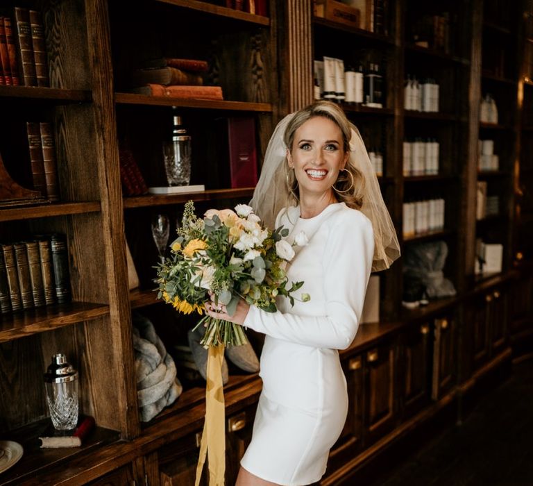 Stylish bride in short wedding dress with yellow bouquet and shoes