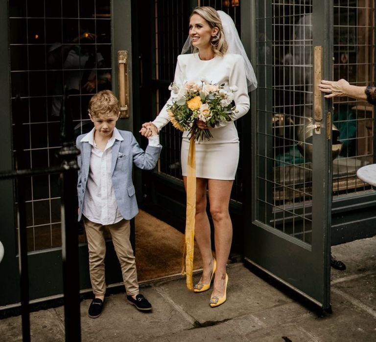 Bride in short wedding dress with yellow shoes holding her sons hand