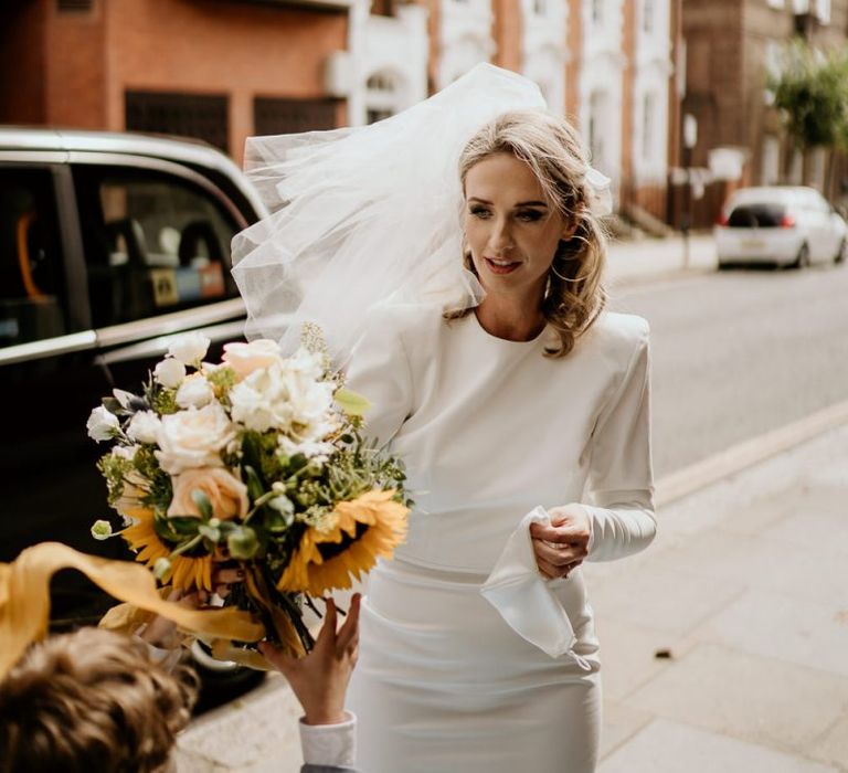 Stylish bride in Alex Perry short wedding dress and veil