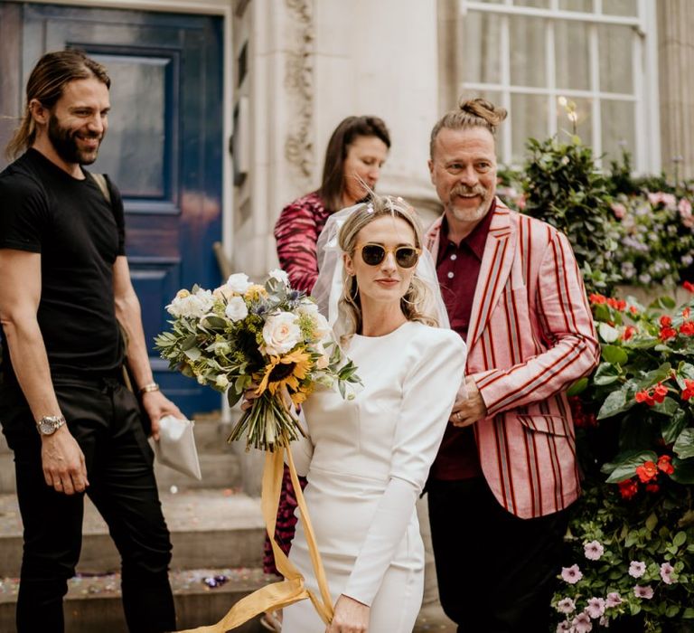 Stylish bride in short wedding dress and sunglasses