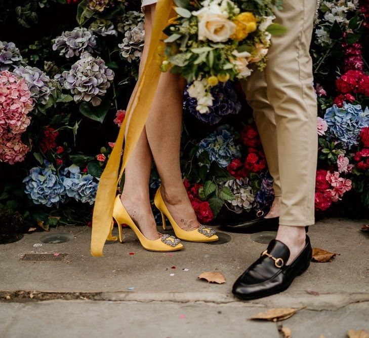 Bride in yellow Manolo Blahnik hangisi pump and groom in loafers