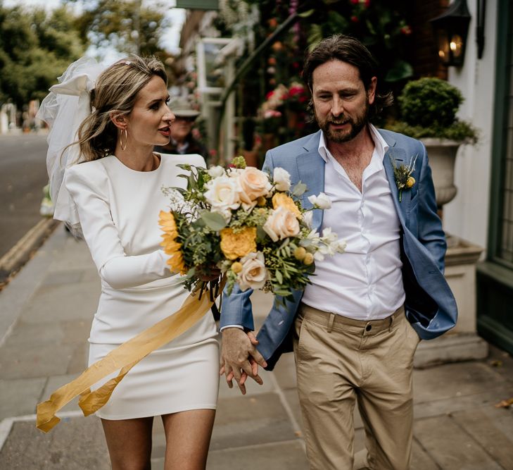 Bride and groom walking through London streets