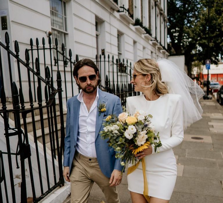 Portrait of bride and groom walking through London