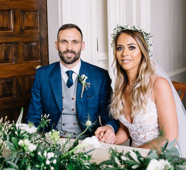 Bride in Mikaella Wedding Dress and Groom in Bespoke Navy Check Suit Signing The Register