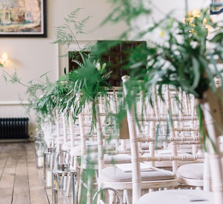 White Aisle Chairs Decorated with Green Foliage