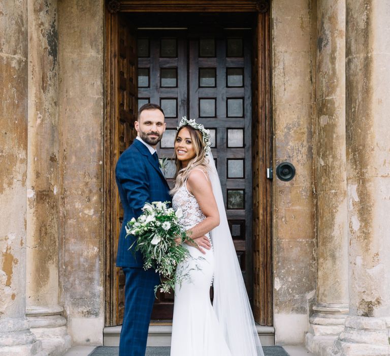 Bride in Fitted Mikaella Wedding Dress with Flower Crown and Groom in Bespoke Navy Check Suit by Territo