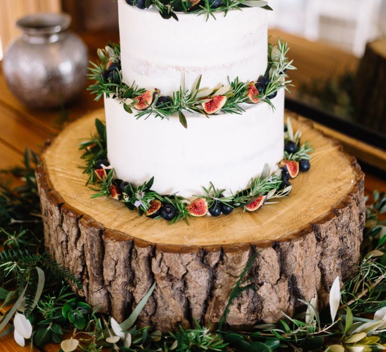 Rustic Wedding Cake Decorated with Foliage and Figs on a Tree Stump Cake Stand