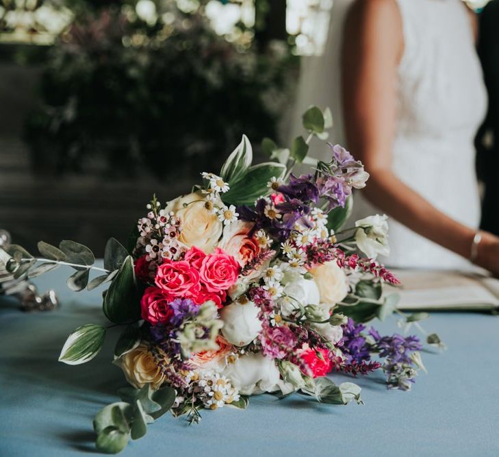 Pink wedding bouquet for bride at wedding with different bridesmaid dresses