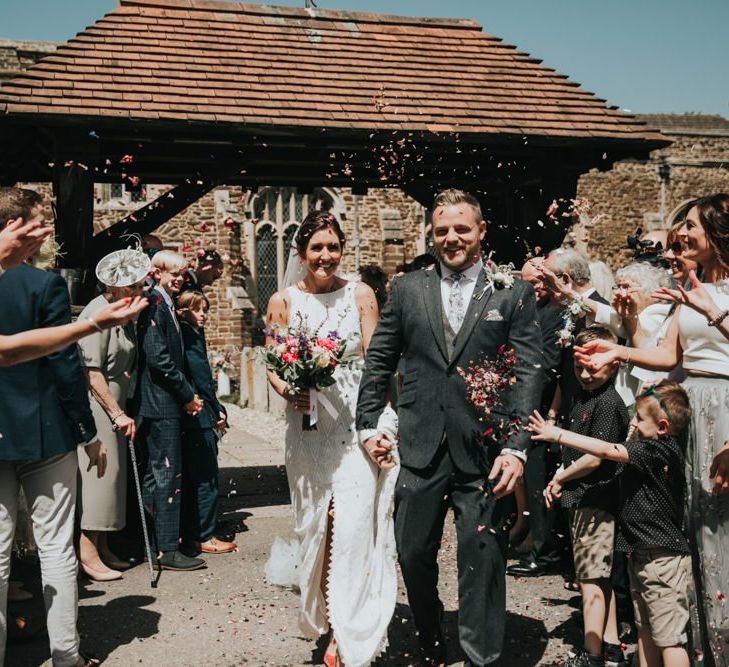 Confetti exit for bride and groom with different bridesmaid dresses