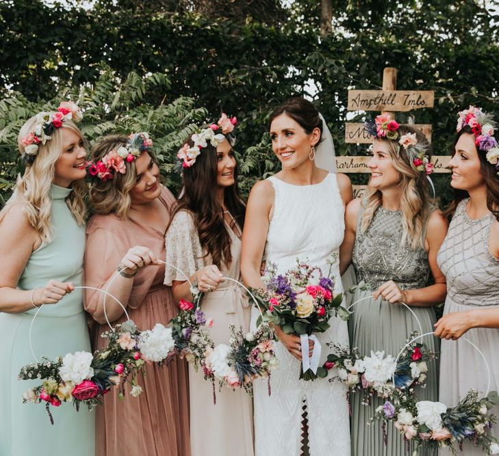 Different bridesmaid dresses with hoop bouquets and flower crowns