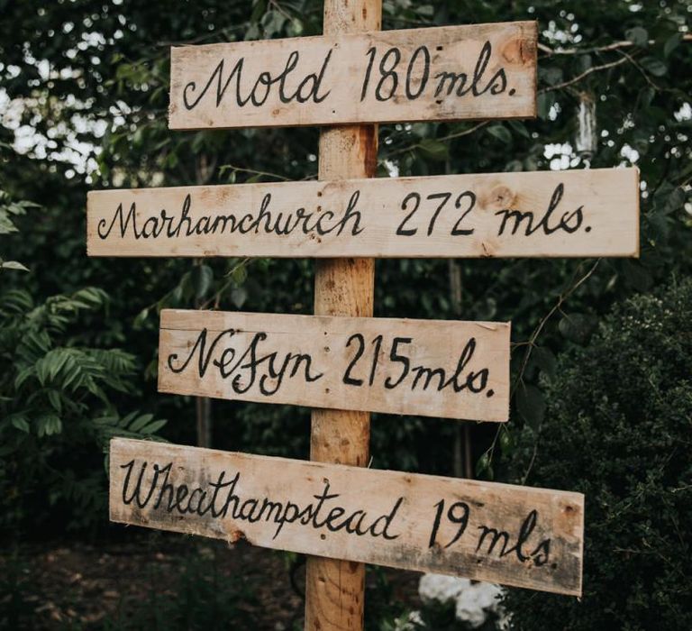 Wooden wedding sign at celebration with different bridesmaid dresses