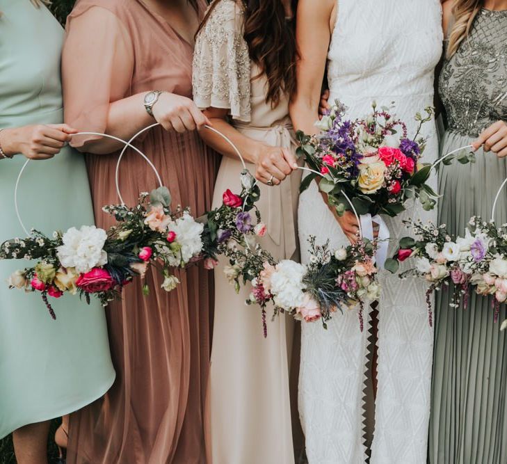 Bridal party in different bridesmaid dresses with hoop bouquets