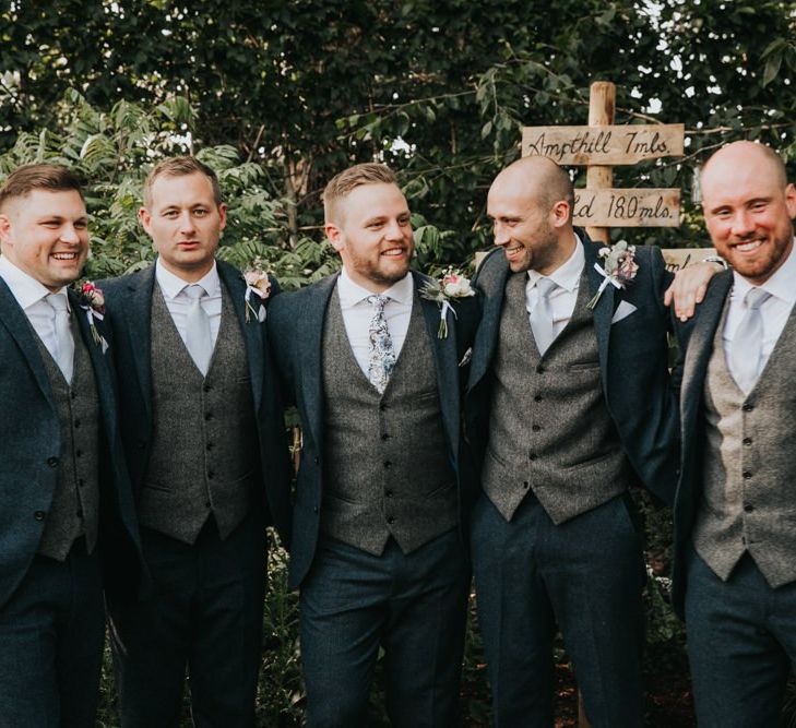 Groomsmen in matching three-piece suits