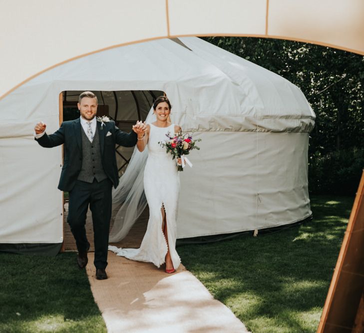 Bride and groom enter wedding marquee with Bridal party in different bridesmaid dresses with hoop bouquets