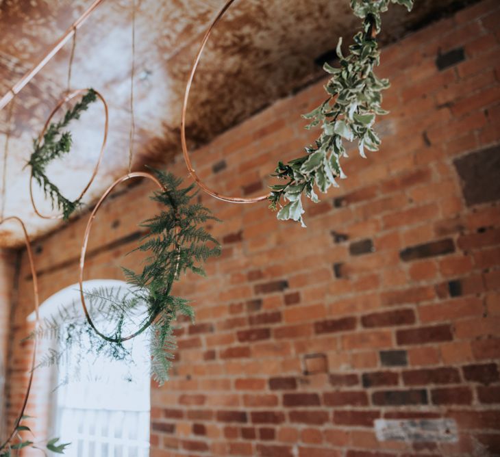 Copper Hoop Decor with Greenery | Pink Roll Top Booze Bath and Copper &amp; Perspex Wedding Decor at Industrial Venue The West Mill | Rosie Kelly Photography