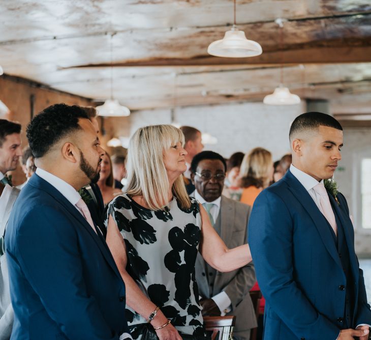 Wedding Ceremony | Groom at the Altar  in Navy Ted Baker Suit | Pink Roll Top Booze Bath and Copper &amp; Perspex Wedding Decor at Industrial Venue The West Mill | Rosie Kelly Photography