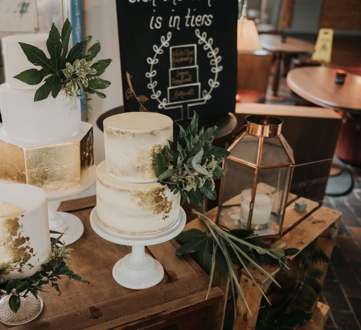 Gold Leaf &amp; White Wedding Cakes with Hexagon Tier | Chalkboard Wedding Sign | Wooden Crates | Pink Roll Top Booze Bath and Copper &amp; Perspex Wedding Decor at Industrial Venue The West Mill | Rosie Kelly Photography