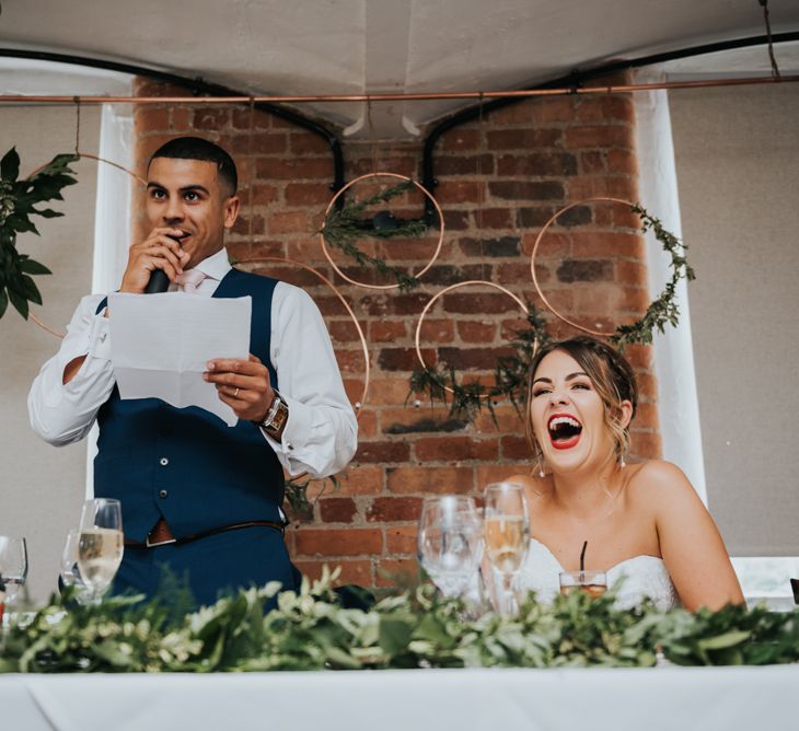 Wedding Reception Speeches | Hoop &amp; Greenery Top Table Backdrop | Bride in Fishtail Allure Bridal Gown | Groom in Navy Ted Baker Suit | Pink Roll Top Booze Bath and Copper &amp; Perspex Wedding Decor at Industrial Venue The West Mill | Rosie Kelly Photography