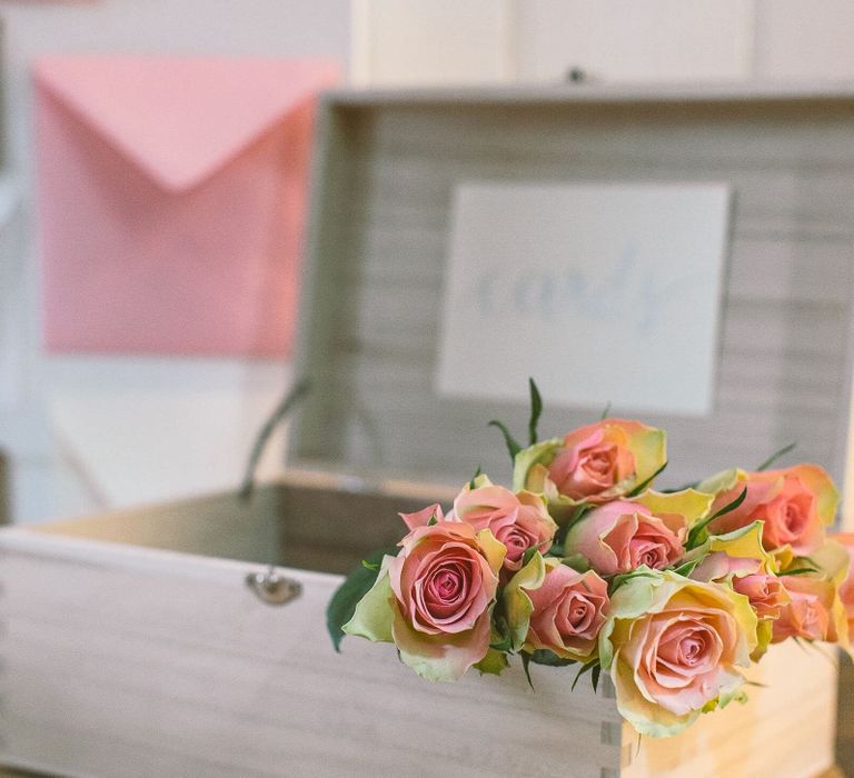 Bunch of pale pink antique roses inside a simple wooden card box