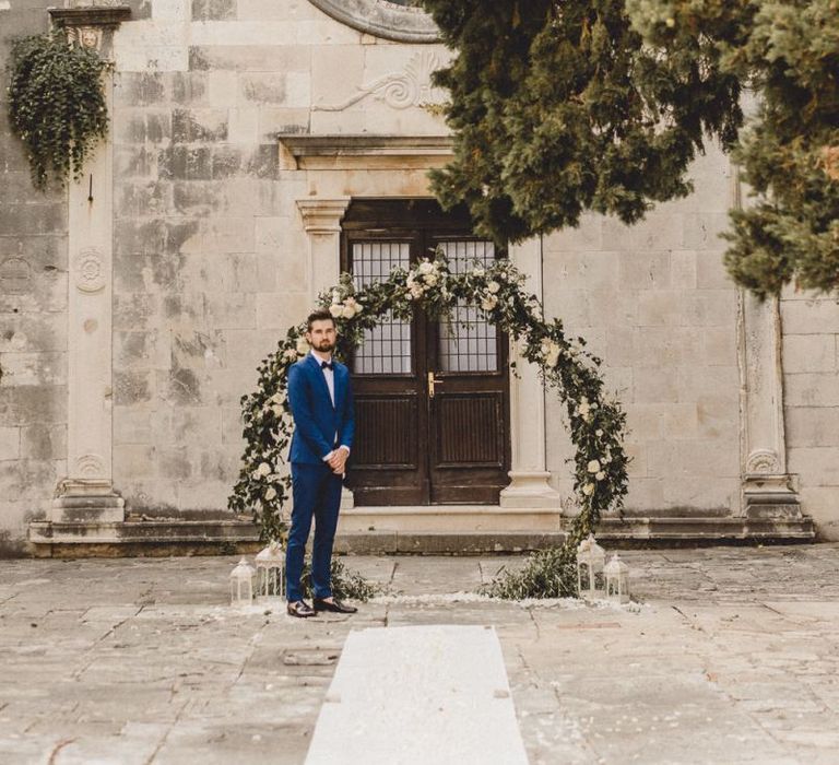 Groom waits for bride at historic church in Croatia