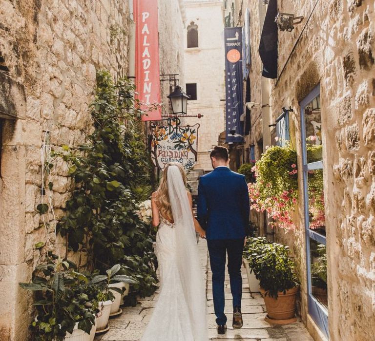 Bride and groom walk through streets of Hvar