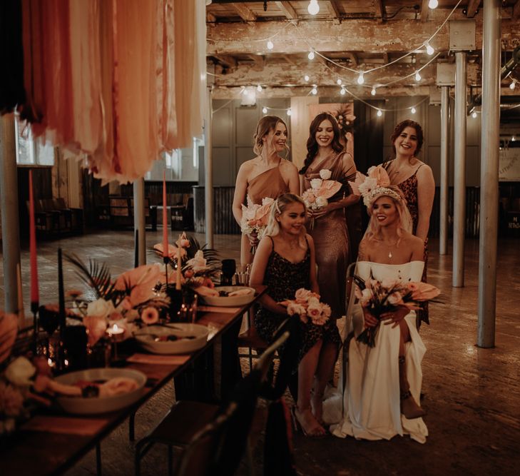 Bridal party in leopard print bridesmaid dresses sitting at the reception table